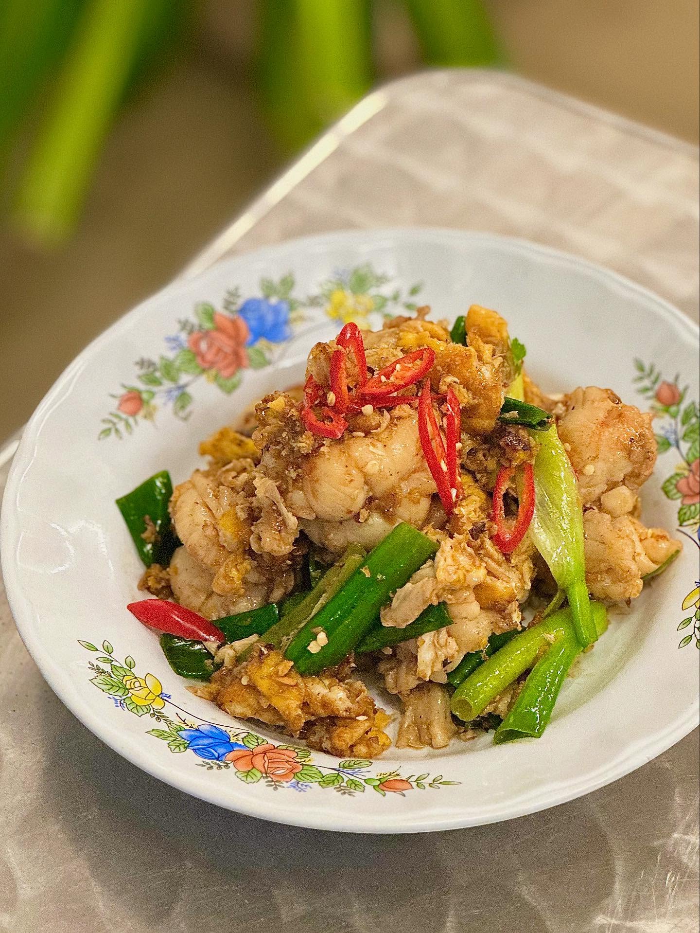 Stir-fried dish with spring onion and sliced red chilli in a floral bowl